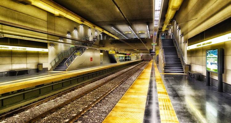 HDR image of an empty modern underground metro station with vivid yellow platforms and symmetrical lines