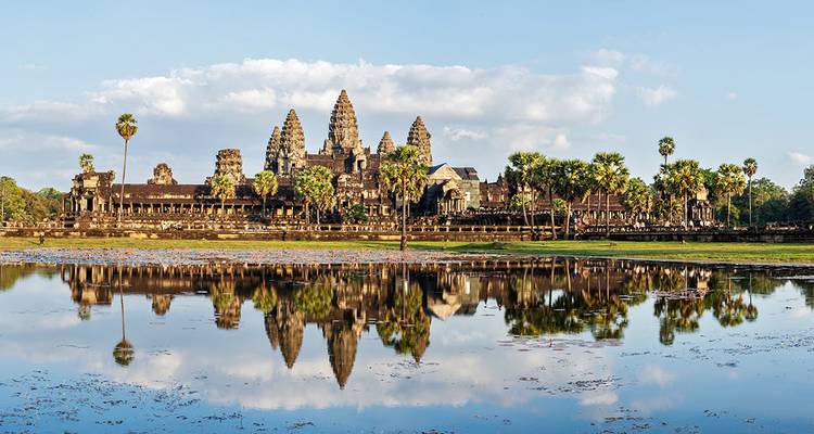 Angkor Wat’s iconic towers reflect perfectly in the still lotus pond at sunrise.