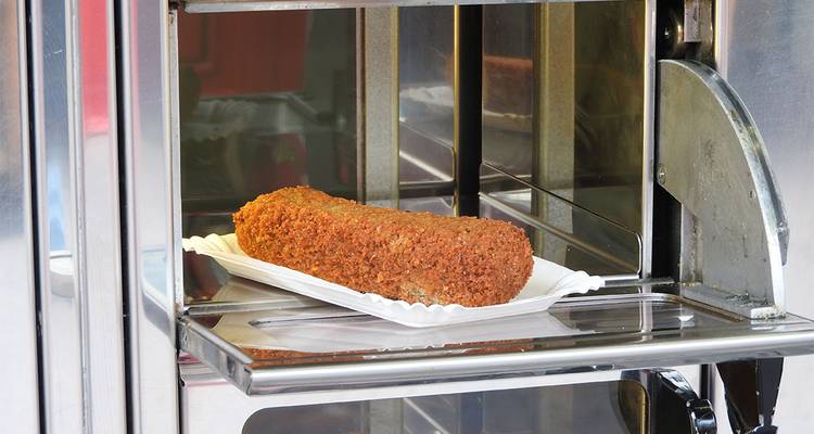 Deep-fried croquette snack displayed inside an automated vending window