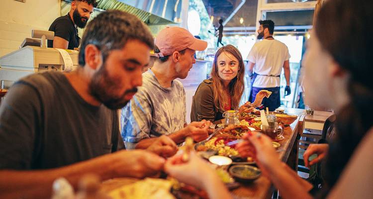 Friends sharing Middle Eastern dishes at a cozy restaurant table