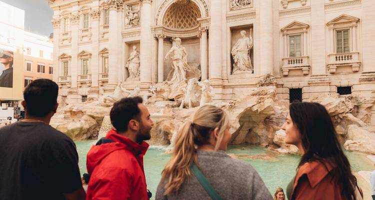 Groupe de voyage observant les sculptures ornées et le bassin turquoise de la Fontaine de Trevi à Rome.