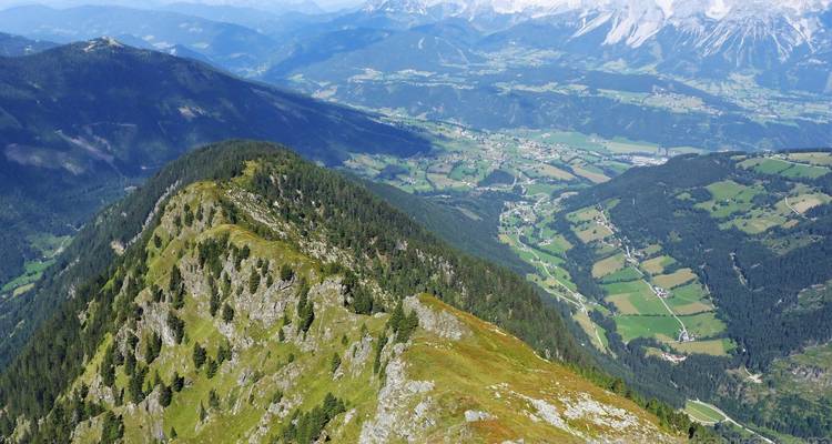 High mountain ridge with forests and patchwork valleys stretching into the distance.