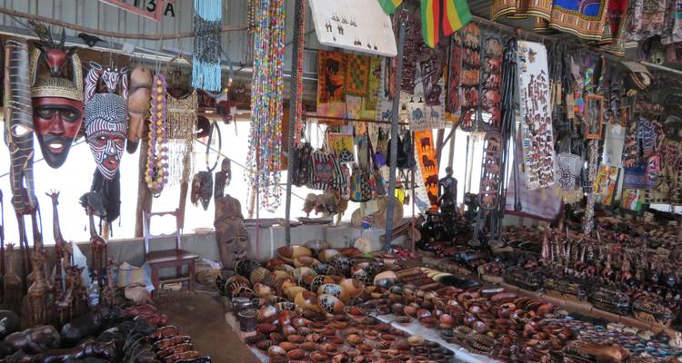 Marché artisanal africain coloré rempli de masques, de perles et de sculptures en bois