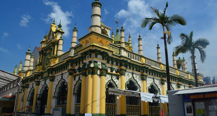 Colorful historic mosque with intricate minarets against a bright blue sky