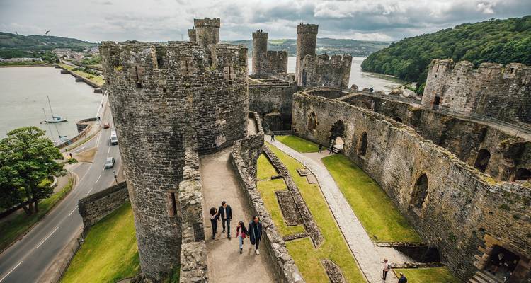 High-angle view over the interior ruins and walls of Conwy Castle beside the estuary.