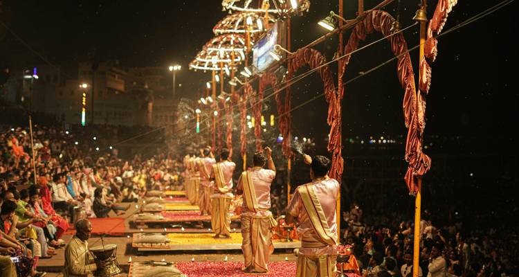 Priests perform the nightly Ganga Aarti ceremony on a brightly lit Varanasi ghat stage.