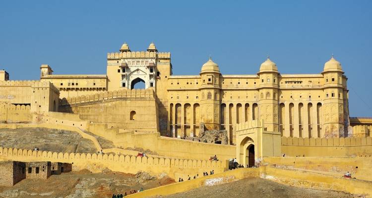 Golden ramparts and domed gateways of Amber Fort rise above rocky Rajasthan hills.