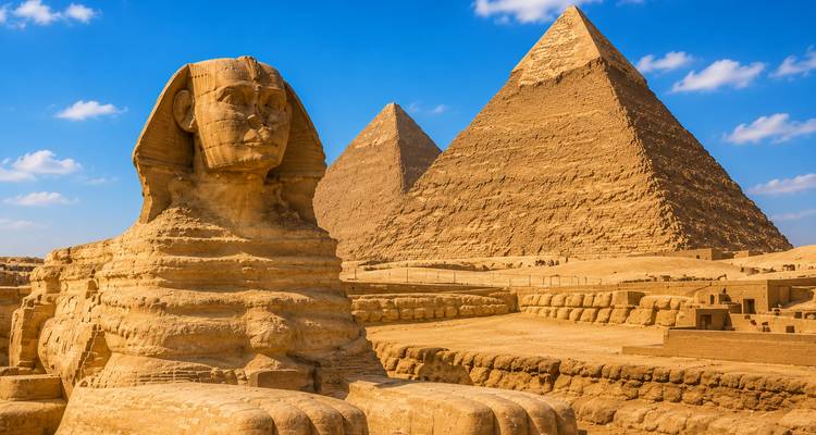 Timeless image of the Sphinx with the Great Pyramids rising behind under deep blue skies.