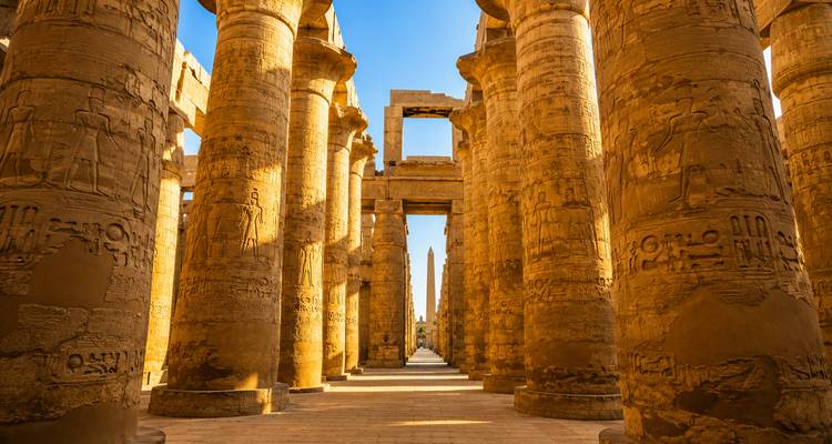 Towering hieroglyph-covered sandstone columns line the hypostyle hall of Karnak Temple at Luxor.