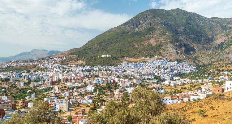 Vue panoramique de la ville de Chefchaouen s'étendant dans une vallée sous une montagne