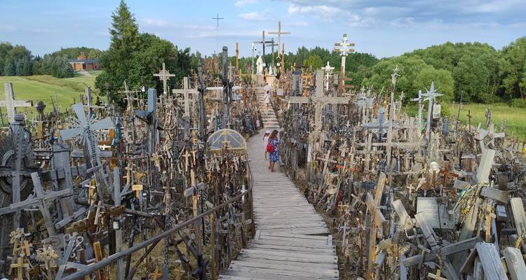 Wooden walkway winding through thousands of devotional crosses at the Hill of Crosses.
