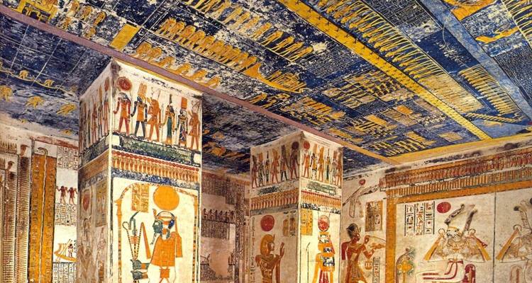Colourful, well-preserved hieroglyphic paintings adorn columns and ceilings inside a pharaonic tomb chamber.