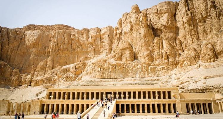 Visitors ascend the long staircase to Hatshepsut’s Temple set against towering golden cliffs in Luxor’s desert valley.
