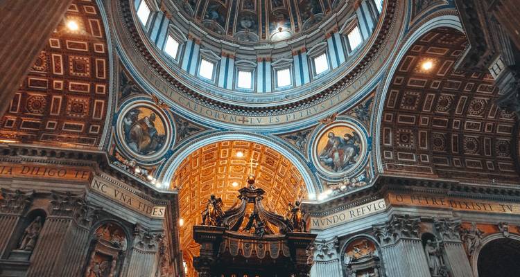 Ornate interior dome and altar area of St Peter's Basilica richly decorated with mosaics and gold