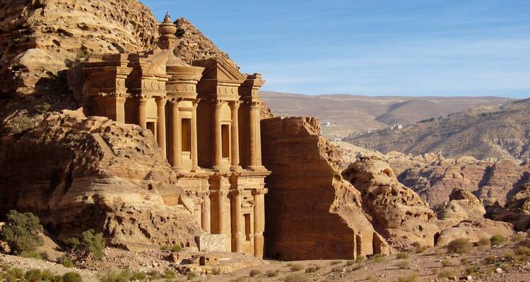El Monasterio en Petra tallado en acantilados de arenisca roja rosada, bañado en la cálida luz de la tarde.