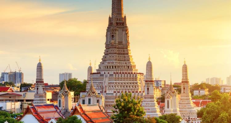 El templo Wat Arun se eleva elegantemente sobre el horizonte de Bangkok bañado en la luz dorada del atardecer