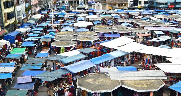 Vue aérienne des étals du marché d'Otavalo couverts de toits de toile circulaires.