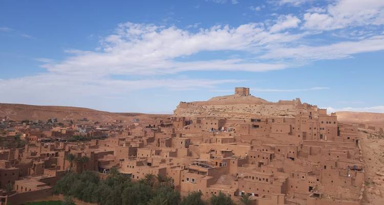 Panoramic view of the ancient hilltop ksar of Ait Benhaddou under a bright blue sky.