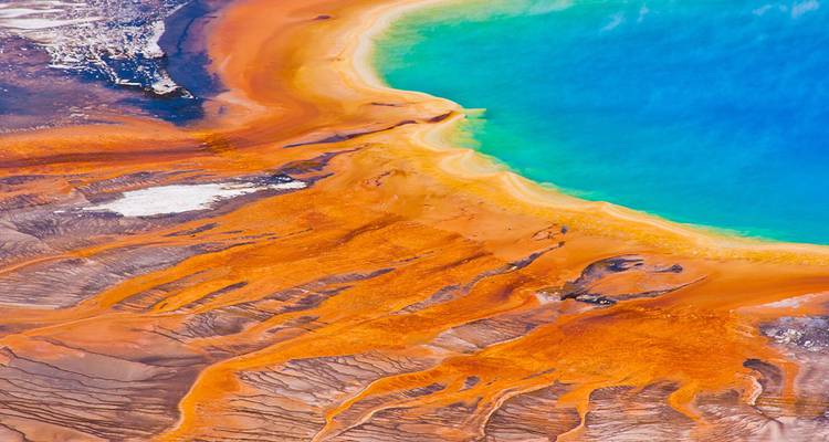 Vue aérienne dynamique de la Grande Source Prismatique de Yellowstone avec des teintes orange et bleu vives.