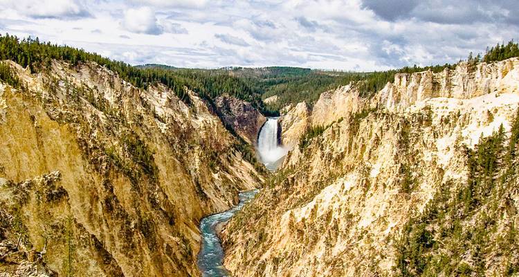 Paysage spectaculaire de canyon avec une haute cascade se jetant dans une rivière sinueuse sous un ciel partiellement nuageux.