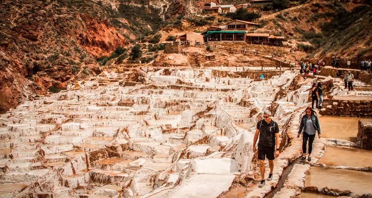 Les visiteurs se promènent le long des remarquables terrasses blanches des salines de Maras situées dans une vallée accidentée.