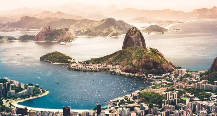 Vista aérea icónica del Pan de Azúcar y la Bahía de Guanabara con el horizonte de Río de Janeiro abajo.
