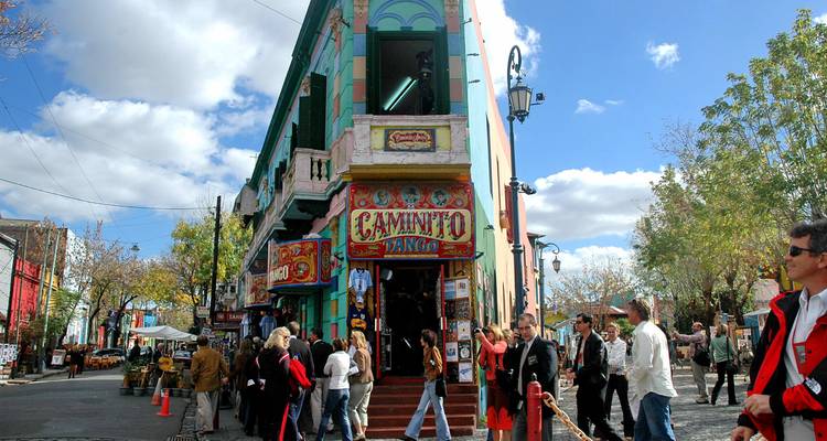 Edificios coloridos y multitudes animadas a lo largo de la famosa calle Caminito en Buenos Aires.