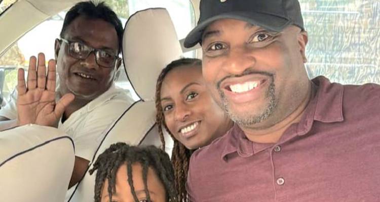 Selfie of travelers and driver inside a vehicle, one waving at the camera.