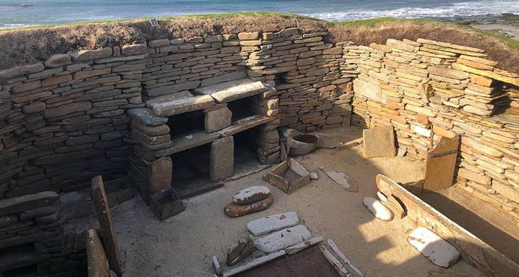 Intérieur en pierre d'une habitation préhistorique avec vue sur la mer à Skara Brae.