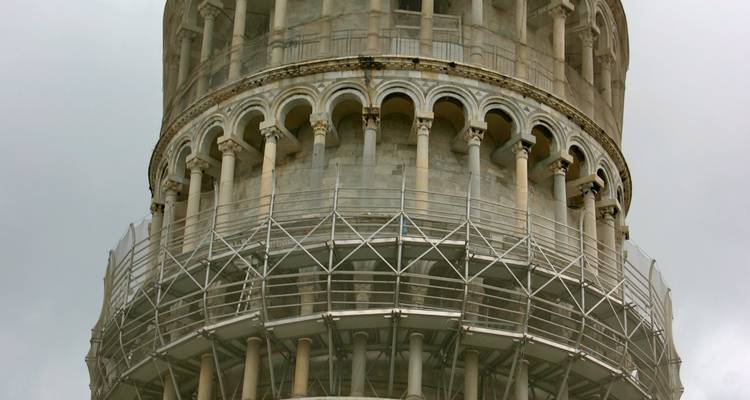 Close detail of the Leaning Tower of Pisa wrapped with stabilising scaffolding.
