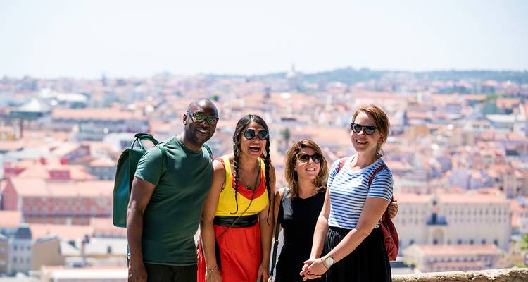 Group posing at a Lisbon viewpoint overlooking the terracotta rooftops and river.