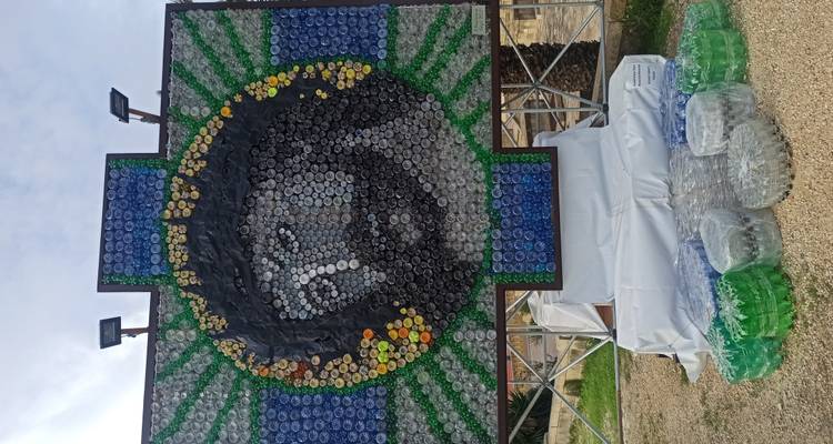 Groot mozaïekportret van Jezus gemaakt van gekleurde plastic flessendoppen buiten tentoongesteld.