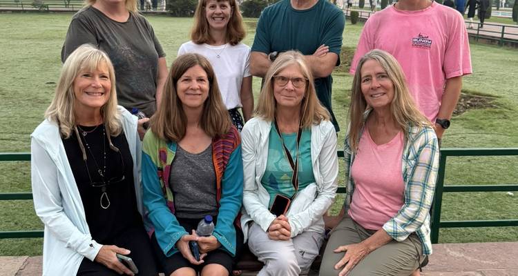 Travellers gather for a casual photo on a park bench early in the morning.