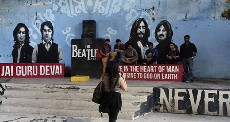 Travelers pose in front of Beatles-themed graffiti inside Rishikesh’s former ashram.
