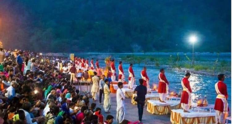 Large assembly watches priests perform evening Aarti rituals beside the Ganges in Rishikesh.