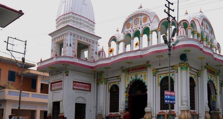 Colorful temple with domed spire and decorative arches against an overcast sky.