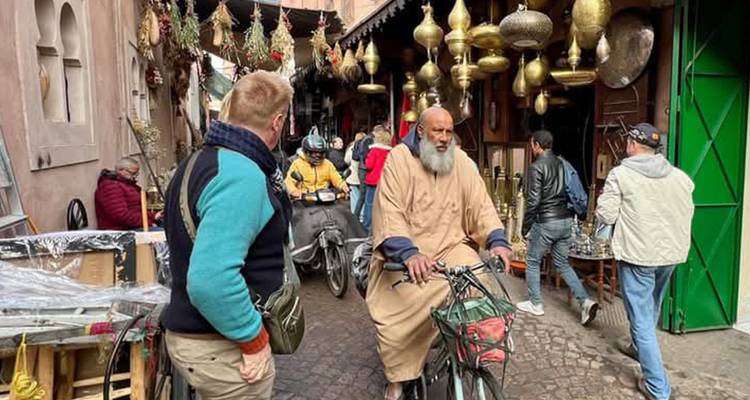 Ruelle étroite et animée du souk avec des habitants, des touristes, des scooters et des lampes en laiton suspendues au-dessus