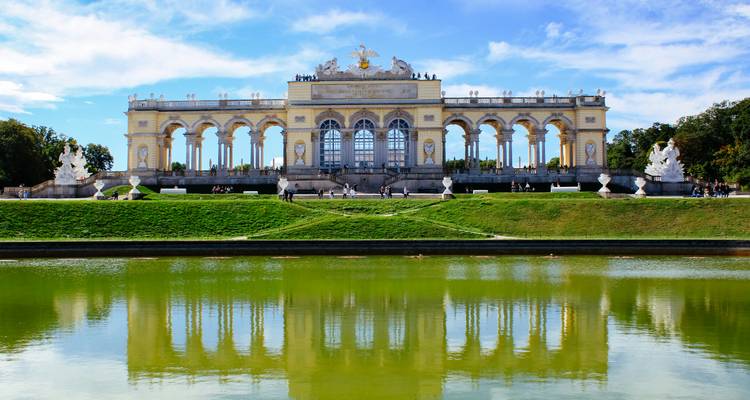 Gloriette pavilion crowns the hill of Schönbrunn gardens reflected in long ornamental pond.