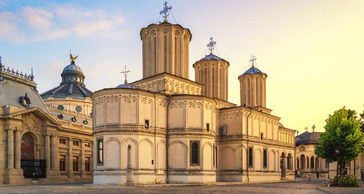 Cathédrale orthodoxe de couleur crème avec plusieurs tours cylindriques illuminées par la lumière de l'aube