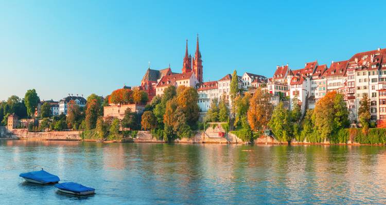 Panoramablick am Morgen auf die Altstadt von Basel und das Münster entlang des ruhigen Rheins.