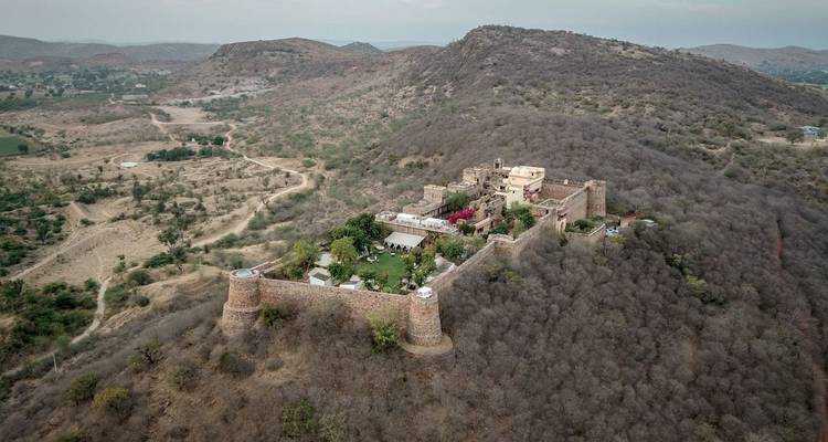 Vue aérienne répétée d'un complexe de fort historique au sommet d'une colline aride avec des murs défensifs