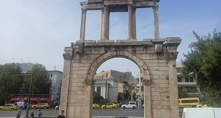 L'Arc d'Hadrien avec le trafic passant et l'Acropole visible à travers l'ouverture à Athènes.