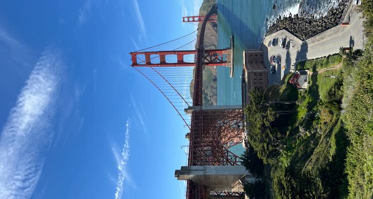 Iconic red towers and cables of the Golden Gate Bridge span the mouth of San Francisco Bay on a bright sunny day.