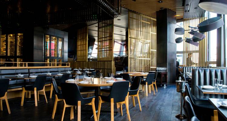 Intérieur de restaurant moderne et élégant avec des tables en bois et des chaises noires attendant les clients