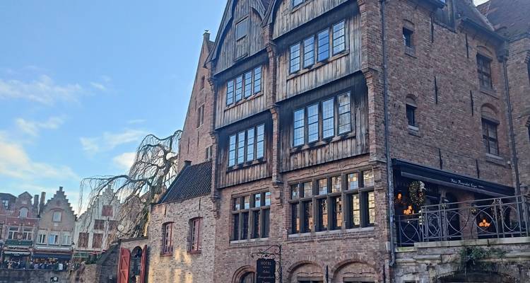 Charming brick and timber canal-side building with balconies and restaurant terrace.