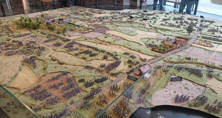 Large detailed diorama of a historic battlefield displayed behind glass.