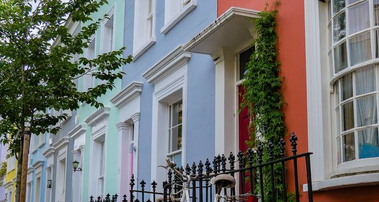 Close-up view of brightly painted terraced houses with wrought-iron railings in Notting Hill