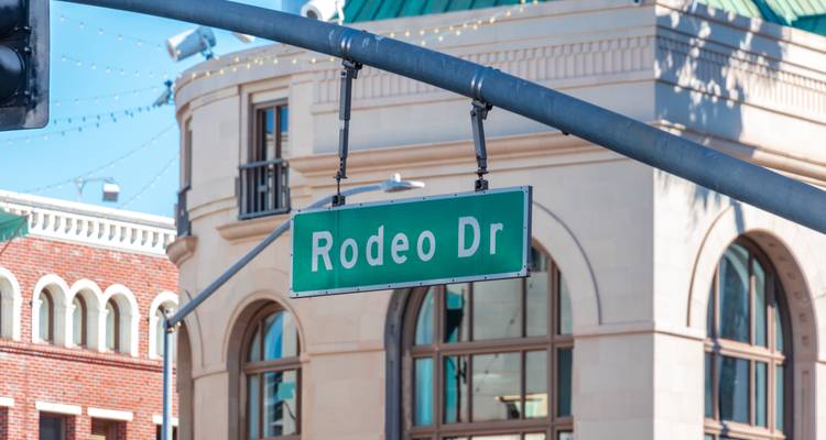 Gros plan d'une pancarte verte « Rodeo Dr » suspendue à un poteau de feu tricolore à Beverly Hills