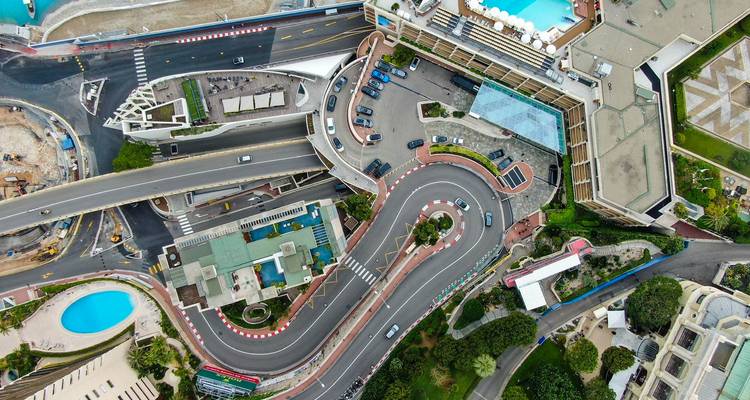 Vue aérienne élevée du célèbre virage en épingle à cheveux du Grand Prix de Monaco, des bâtiments environnants, des piscines et de la marina.
