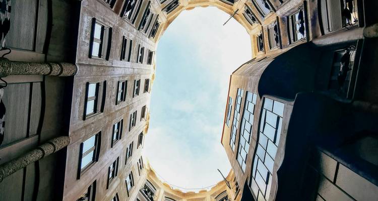 Vue ascendante depuis une cour circulaire vers le ciel bleu entouré de murs d'appartements